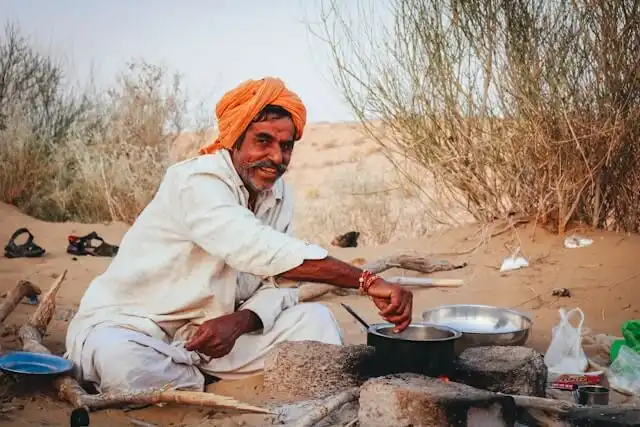 Rajasthani man cooking in the desert